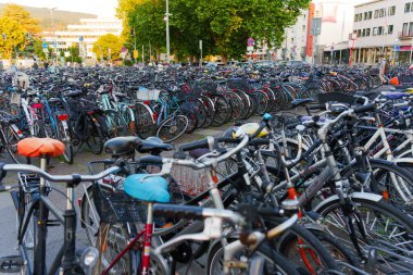 Heidelberg, Almanya - 21 Haziran 2025: Doğal gün ışığı altında çeşitli bisikletlerle dolu bir şehirde kalabalık bisiklet park alanı.
