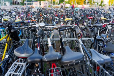 Heidelberg, Almanya - 21 Haziran 2025: Yoğun bisiklet park alanı çeşitli bisiklet ve oturma yerleri ile dolu, gün ışığında yakalandı.