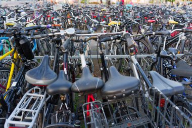 Heidelberg, Almanya - 21 Haziran 2025: Gündüz saatlerinde kalabalık bir bisiklet parkında park edilmiş çeşitli bisikletlerin yoğun aranjmanı.