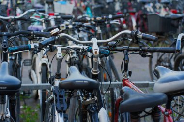 Heidelberg, Almanya - 21 Haziran 2025: Kalabalık bir şehir ortamında parketmiş çoklu bisikletlerin yakın görüntüsü, gidon ve bisiklet çerçevelerinin ayrıntılarını gözler önüne seriyor.
