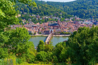 Eski Köprü 'nün panoramik manzarası, Neckar Nehri, ve Heidelberg şehri berrak gökyüzü altında.