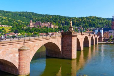 Heidelberg, Almanya - 21 Haziran 2025: Heidelberg 'deki Iconic Eski Köprüsü tarihi mimarisi ile Neckar Nehri boyunca uzanır.