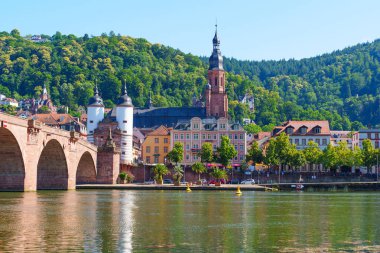 Heidelberg, Almanya - 21 Haziran 2025: Heidelberg 'deki Eski Köprü' nün geniş açılı görüntüsü, açık gökyüzü altındaki kemerleri ve yakınlardaki binaları gösteriyor.