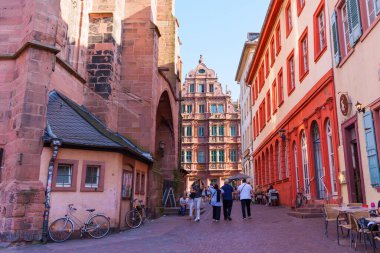 Heidelberg, Almanya - 21 Haziran 2025: Heidelberg 'deki canlı sokak sahnesi, tarihi mimari ve aydınlık gün ışığında bölgeyi keşfeden ziyaretçileri gözler önüne seriyor.