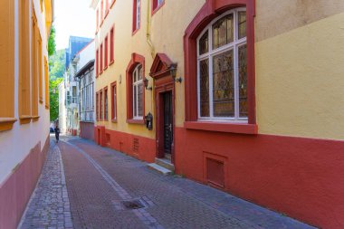 Heidelberg, Almanya - 21 Haziran 2025: Heidelberg, Almanya 'da dar bir sokak, parlak gün ışığı altında renkli binalar ve kaldırımlar sergileniyor.
