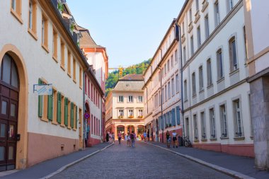 Heidelberg, Almanya - 21 Haziran 2025: Heidelberg 'de canlı sokak manzarası, günbatımında tarihi binalar ve canlı yayalar sergileniyor.
