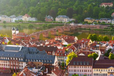Heidelberg 'in Eski Köprü' yü, renkli çatıları ve altın saat boyunca Neckar Nehri 'nin yanındaki yeşil tepeleri gözler önüne serişi..