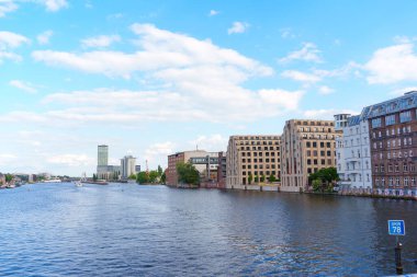 Berlin, Almanya - 30 Mayıs 2025: Berlin 'deki Spree Nehri' ni çevreleyen çağdaş binaların geniş açılı görünümü, eşsiz mimarilerini parlak, güneşli bir gökyüzü altında sergiliyor.