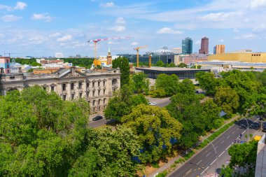 Berlin, Almanya - 31 Mayıs 2025: Berlin 'deki Sosyal Bilimler Araştırma binası, canlı yeşillikler ve turna ve modern mimarinin yer aldığı kentsel ufuk çizgisi tarafından çerçevelendi.