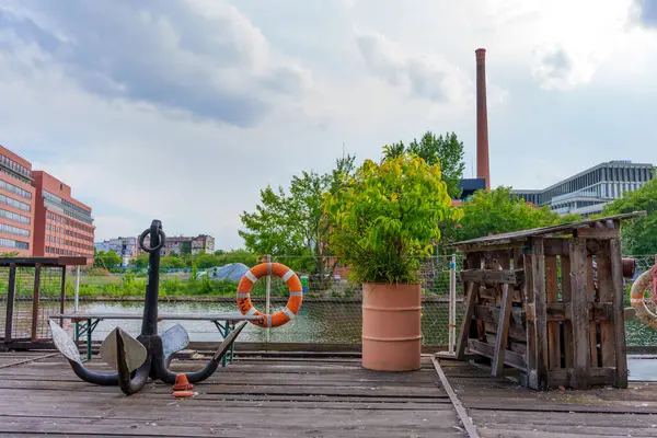 Berlin, Almanya - 31 Mayıs 2025 Berlin 'deki Holzmarkt sahnesinde sunucu, can simidi ve yeşillik yer aldı. Arka plandaki sanayi binaları bulutlu bir gökyüzünün altında.
