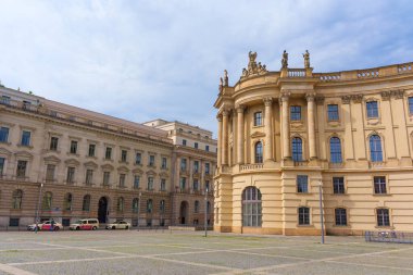 Berlin, Almanya - 1 Haziran 2025: Berlin 'deki Humboldt Üniversitesi binaları, klasik mimari, karmaşık detaylar ve parlak mavi gökyüzü altında geniş bir meydan.