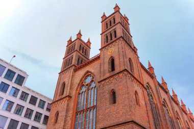 Berlin, Almanya - 1 Haziran 2025: Friedrichswerder Kilisesi 'nin mimari detayları, ikiz kuleleri, karmaşık tuğlaları ve büyük vitray pencereleri ile.