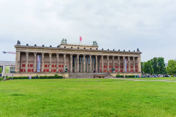 Berlin, Almanya - 1 Haziran 2025: Berlin 'deki tarihi Altes Müzesi' nde yeşil çimlerle çevrili bulutlu bir gökyüzüne karşı neoklasik mimari sergilenen büyük sütunlar ve heykeller yer alıyor..