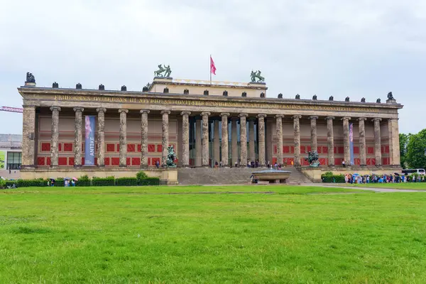 Berlin, Almanya - 1 Haziran 2025: Berlin 'deki Altes Müzesi' nin büyük sütunlarını, klasik mimarisini ve bulutlu bir gökyüzü altında yemyeşil çevreleri vurguluyor..