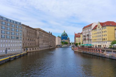 Berlin, Almanya - 1 Haziran 2025: Spree Nehri boyunca tarihi binalar tarafından çerçevelenen Berlin Katedrali 'nin panoramik manzarası, kentin mimari çeşitliliği ve canlı atmosferini yansıtıyor.