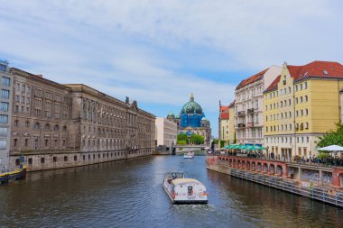 Berlin, Almanya - 1 Haziran 2025: Berlin Katedrali 'nin tarihi binalar ve modern yaşamın ortasında yer aldığı nehir manzarası, şehrin canlı özünü su üzerinde kayıklarla yakalıyor..