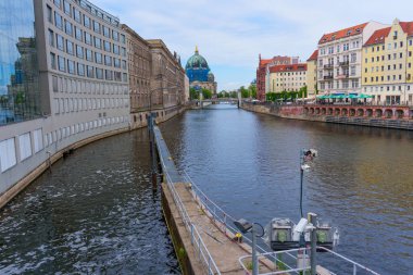 Berlin, Almanya - 1 Haziran 2025: Berlin Katedrali 'nin hakim olduğu Spree Nehri' nin sakin manzarası, tarihi binalar ve temiz bir gökyüzü altında modern mimari ile çevrili..