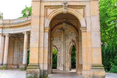 Berlin, Almanya - 1 Haziran 2025: Berlinli Spittelkolonnaden 'in mimari güzelliğini gösteren yemyeşil ile çevrili karmaşık taş kemerler ve klasik sütunlar.