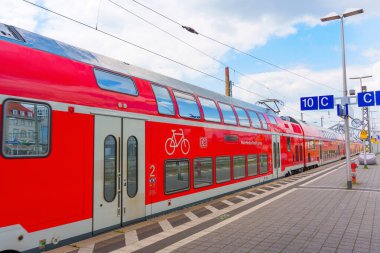 Darmstadt, Almanya - 16 Haziran 2025: Darmstadt tren istasyonunda park etmiş kırmızı çift katlı bir trenin yakın görüntüsü, bisiklet sembolü, kentsel ulaşım ve modern altyapı görüntüsü
