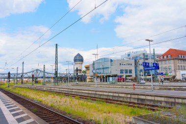 Darmstadt, Almanya - 16 Haziran 2025: Rayların, modern mimarinin ve Almanya 'nın Darmstadt kentinde bulutlu bir gökyüzünün altında tarihi bir su kulesinin yer aldığı tren istasyonu manzarası.