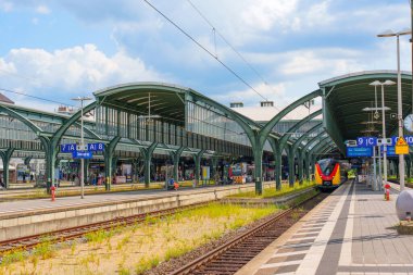 Darmstadt, Almanya - 16 Haziran 2025: Almanya 'nın Darmstadt kentinde modern mimari, çelik yapılar ve canlı gökyüzünün yer aldığı tren istasyonu platformu.