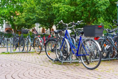 Darmstadt, Almanya - 16 Haziran 2025: Çeşitli bisikletlerle dolu bisiklet park alanı, Almanya 'nın Darmstadt kentinde yemyeşil bir alana kurulmuştur..