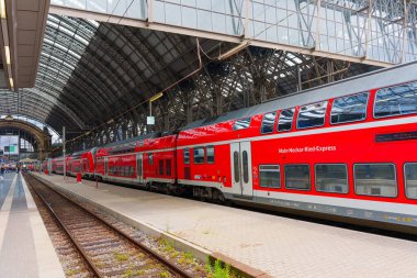 Frankfurt, Almanya - 10 Haziran 2025: Frankfurt Merkez İstasyonu 'ndaki platformlarda çarpıcı cam çatı ve endüstriyel mimarinin yer aldığı çift katlı kırmızı trenler.