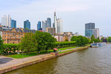 Frankfurt, Almanya - 10 Haziran 2025: Frankfurt 'un modern gökdelenlerinin ve Main River boyunca uzanan yemyeşil nehir parkının panoramik manzarası.