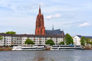 Frankfurt, Almanya - 10 Haziran 2025: St. Bartholomew Katedrali tarihi ve çağdaş mimarinin bir karışımını göstererek Frankfurt 'taki Main River boyunca yer alan modern binalara belirgin bir şekilde karşı yükseliyor