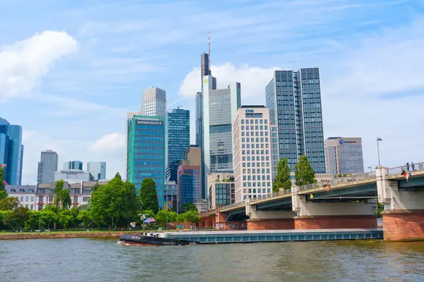 Frankfurt, Almanya - 10 Haziran 2025: Frankfurt 'un ana nehir boyunca uzanan modern gökdelenlerin ve bir köprünün panoramik manzarası, canlı kent manzarası ve mimarisini vurguluyor.
