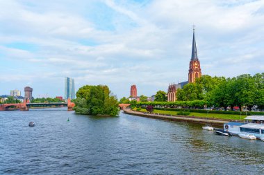 Frankfurt, Almanya - 10 Haziran 2025: Saint Bartholomew İmparatorluk Katedrali 'nin panoramik manzarası yemyeşil ve Ana Nehir ile çevrili bulutlu bir gökyüzüne karşı kurulmuştur..