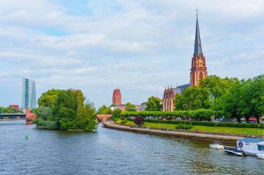 Frankfurt, Almanya - 10 Haziran 2025: Bereketli yeşillik ve nehir ile çevrili Saint Bartholomew İmparatorluk Katedrali 'nin panoramik manzarası.