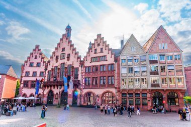 Frankfurt, Almanya - 10 Haziran 2025: Roemer 'in mimari detayları, Frankfurt' un Roemerberg meydanındaki tarihi bir bina, parlak bir gökyüzü altında, canlı kent yaşamını gösteren ziyaretçilerle dolu.