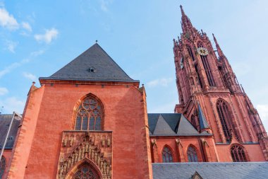 Frankfurt, Almanya - 10 Haziran 2025: Frankfurt Katedrali 'nin açık gökyüzü altındaki karmaşık mimarisi ve yüksek kulesinin ayrıntılı görüntüsü, kırmızı kumtaşı cephesini ve gotik unsurları vurguluyor.