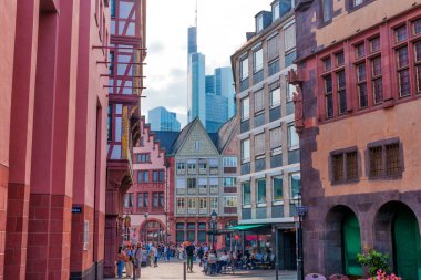 Frankfurt, Almanya - 10 Haziran 2025: Geleneksel mimari ve modern siluet arkaplanının yer aldığı canlı bir Roemerberg Meydanı sahnesi, kentin tarihsel ve çağdaşlığın eşsiz harmanını vurguluyor.