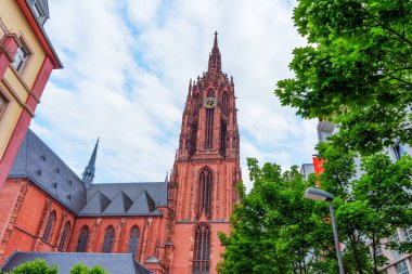 Frankfurt, Almanya - 10 Haziran 2025: Saint Bartholomew İmparatorluk Katedrali 'nin çarpıcı perspektifi, karmaşık Gotik mimari, yemyeşil ve dinamik bir arkaplan.