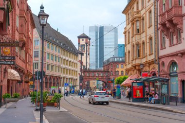 Frankfurt, Almanya - 10 Haziran 2025: Tarihi binalar ve modern gökdelenlerin karışımı, Frankfurt 'taki canlı sahneyi dolduran insan ve araçların yer aldığı canlı sokak manzarası.
