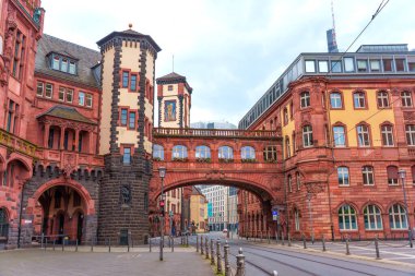 Frankfurt, Almanya - 10 Haziran 2025: Frankfurt, Almanya 'daki İç Çekiş Köprüsü mimari görünümü, belirgin kırmızı kumtaşı yapıları, karmaşık ayrıntılar ve bulutlu bir gökyüzü.