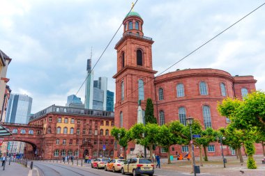 Frankfurt, Almanya - 10 Haziran 2025: Frankfurt 'taki modern binalar tarafından çerçevelenen St. Paul Kilisesi' nin dış görünüşü, çağdaş bir ufuk çizgisine karşı tarihi mimarinin karşıtlığını gözler önüne seriyor..