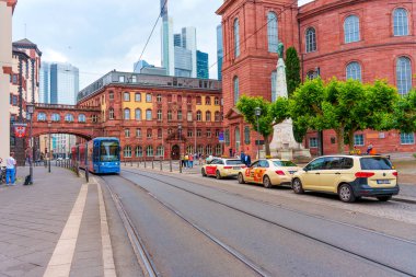 Frankfurt, Almanya - 10 Haziran 2025: Frankfurt, Almanya 'da St. Paul Kilisesi, tramvay hatları ve taksilerin yer aldığı şehir sahnesi, tarihi ve modern mimarinin bir karışımını sergiliyor.