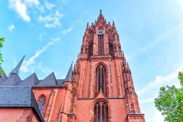 Aziz Bartholomew İmparatorluk Katedrali 'nin uzun Gotik kulesi dağınık bulutlarla dolu mavi gökyüzüne uzanıyor ve karmaşık mimari detaylar sergiliyor..