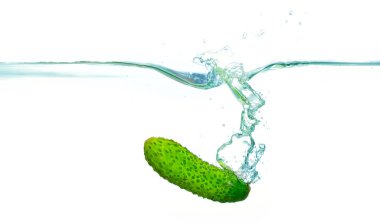 Salatalık berrak sularda yüzüyor kabarcıklar yükseliyor ve sıçrıyor, tazelik ve su dinamikleri sergiliyor..