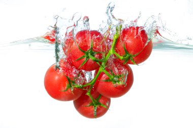 Canlı renklerini ve tazeliklerini gözler önüne seren, kabarcıklar ve sıçramalarla çevrili, berrak suya sıçrayan taze kırmızı kiraz domateslerinin dinamik bir sahnesi..
