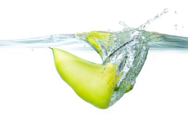 Canlı yeşil biber dinamik sıçramalar yaratıyor, berrak suya batıyor, tazelik ve canlılık sergiliyor..