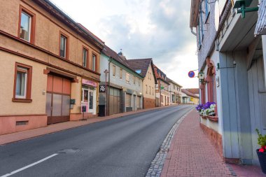 Rossdorf, Almanya - 23 Haziran 2025: Geleneksel mimari, kaldırım taşları ve Avrupa köyünün cazibesini sergilemek için ideal sakin bir atmosfere sahip Rossdorf, Almanya 'nın sokak manzarası.