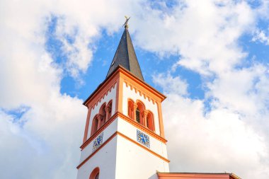 Rossdorf, Almanya - 23 Haziran 2025: Bölgenin mimari güzelliğini ve kültürel mirasını gözler önüne seren, Rossdorf, Almanya 'da parlak bir gökyüzü altında karmaşık tasarım detayları içeren kilise kulesi.