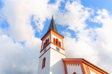 Rossdorf, Almanya - 23 Haziran 2025: Tarihi bir kilise kulesinin mimari ayrıntıları saat ve Almanya 'nın Rossdorf kentindeki dinamik bulutlu gökyüzü altında kule.