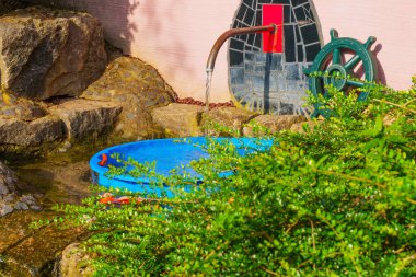 Darmstadt 'taki Waldspirale konut kompleksinin renkli mimari unsurları, yemyeşil ve taşlarla çevrili, eşsiz spiral tasarımı içerir..