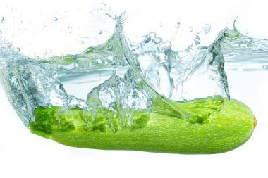 Canlı bir kabağın berrak suya girişi, dinamik sıçrama efektleri ve dalgalanmalar yaratması, tazeliği ve doğal güzelliği vurguluyor..