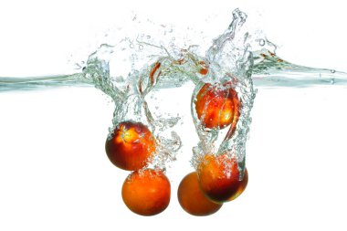 Canlı domatesler berrak suya sıçrıyor, dinamik hareketleri ve dokuları canlı ve canlandırıcı bir sahnede yakalıyor..